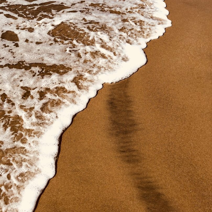 Strand, Sandra Gütter Schäumendes Wasser, das sanft den goldenen Sandstrand umspült.